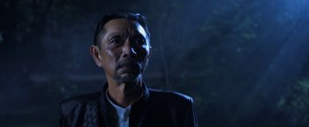 Movie still from “Elephant White” (2011), directed by Prachya Pinkaew – A person wearing a jacket; Close Up shot, Low angle