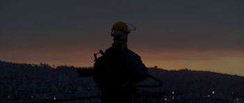 Movie still from “Ema” (2019), directed by Pablo Larraín – A person with a gas mask and a helmet on; Medium shot, Low angle