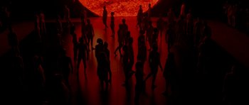 Movie still from “Ema” (2019), directed by Pablo Larraín – A group of people standing in front of a red sun; Extreme Wide shot, High angle