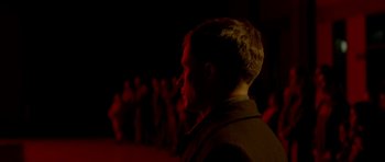 Movie still from “Ema” (2019), directed by Pablo Larraín – A man standing in front of a group of people; Medium shot, Over the shoulder angle