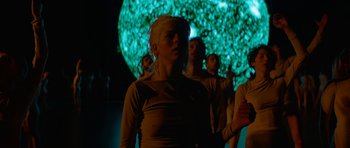 Movie still from “Ema” (2019), directed by Pablo Larraín – A group of people standing in front of a projection screen; Medium shot, Low angle