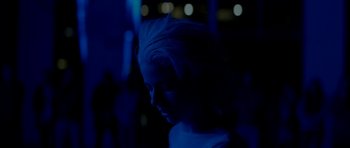 Movie still from “Ema” (2019), directed by Pablo Larraín – A woman in a white shirt is in the dark; Close Up shot, Low angle