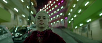 Movie still from “Ema” (2019), directed by Pablo Larraín – A woman in a red jacket standing on a sidewalk; Close Up shot, Low angle