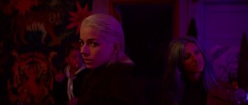 Movie still from “Ema” (2019), directed by Pablo Larraín – A woman with blonde hair is standing in a dark room; Close Up shot, Over the shoulder angle