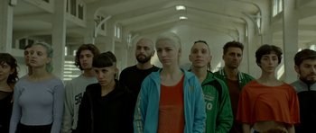 Movie still from “Ema” (2019), directed by Pablo Larraín – A group of young people standing in a room together; Medium shot, Low angle