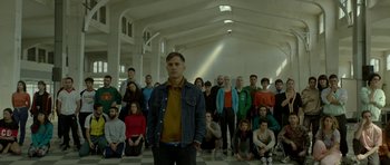 Movie still from “Ema” (2019), directed by Pablo Larraín – A man standing in front of a large group of people; Wide shot, High angle