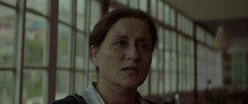 Movie still from “Ema” (2019), directed by Pablo Larraín – A woman's face in front of a window; Close Up shot, Low angle