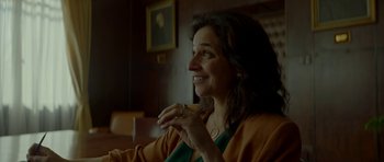 Movie still from “Ema” (2019), directed by Pablo Larraín – A woman sitting in front of a wall with her hand up to her mouth; Close Up shot, Over the shoulder angle