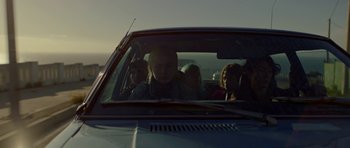 Movie still from “Ema” (2019), directed by Pablo Larraín – A group of people sitting in the back seat of a car; Medium shot, Low angle