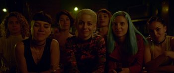 Movie still from “Ema” (2019), directed by Pablo Larraín – A group of young women sitting next to each other in a room; Close Up shot, High angle