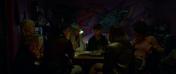 Movie still from “Ema” (2019), directed by Pablo Larraín – A group of people sitting around a table; Medium shot, Over the shoulder angle