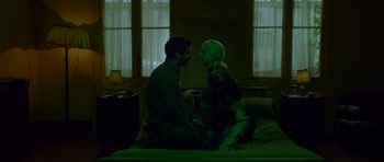 Movie still from “Ema” (2019), directed by Pablo Larraín – A man and a woman sitting on top of a bed; Wide shot, Overhead angle