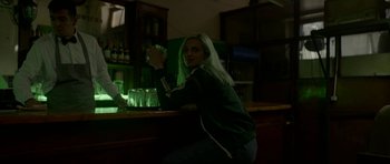 Movie still from “Ema” (2019), directed by Pablo Larraín – A woman sitting at a bar holding a glass; Medium shot, Low angle