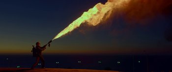 Movie still from “Ema” (2019), directed by Pablo Larraín – A person is blowing smoke from an object in the sky; Extreme Wide shot, Low angle