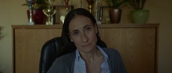 Movie still from “Ema” (2019), directed by Pablo Larraín – A person sitting in a chair; Close Up shot, Over the shoulder angle