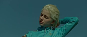 Movie still from “Ema” (2019), directed by Pablo Larraín – A woman with blonde hair is wearing a blue jacket; Close Up shot, Low angle