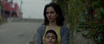 Movie still from “Ema” (2019), directed by Pablo Larraín – A woman standing next to a young boy in front of trees; Close Up shot, Low angle