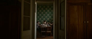 Movie still from “Ema” (2019), directed by Pablo Larraín – A group of people sitting at a table with wine glasses on it; Wide shot, High angle
