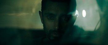 Movie still from “Encounter” (2021), directed by Michael Pearce – A person's face in a dark room; Close Up shot, Low angle