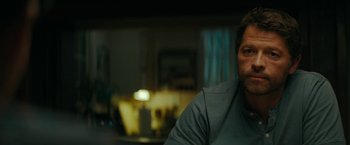 Movie still from “Encounter” (2021), directed by Michael Pearce – A person sitting at a table; Close Up shot, Over the shoulder angle