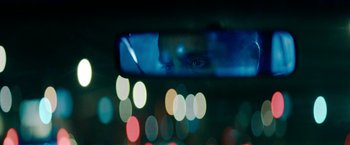 Movie still from “Encounter” (2021), directed by Michael Pearce – A man's reflection in the side view mirror of a car; Extreme Close Up shot, Over the shoulder angle