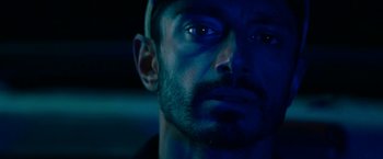 Movie still from “Encounter” (2021), directed by Michael Pearce – A man's face in blue light; Close Up shot, Overhead angle