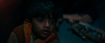 Movie still from “Encounter” (2021), directed by Michael Pearce – A young boy with blue eyes is looking at the camera; Close Up shot, High angle