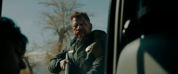Movie still from “Encounter” (2021), directed by Michael Pearce – A man in a green jacket sitting in a car; Close Up shot, Over the shoulder angle