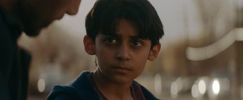 Movie still from “Encounter” (2021), directed by Michael Pearce – A young boy is looking into the camera; Close Up shot, Over the shoulder angle