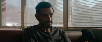 Movie still from “Encounter” (2021), directed by Michael Pearce – A person sitting in front of a window; Close Up shot, Over the shoulder angle