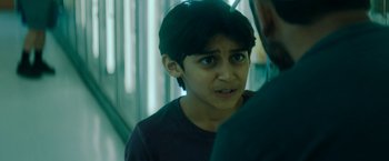 Movie still from “Encounter” (2021), directed by Michael Pearce – A young boy looking at a man in a room; Close Up shot, Over the shoulder angle