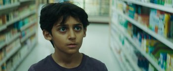 Movie still from “Encounter” (2021), directed by Michael Pearce – A young boy with blue eyes stares into the camera; Close Up shot, Low angle