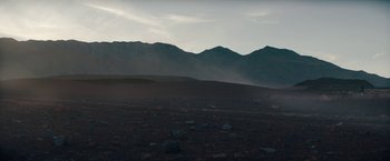 Movie still from “Encounter” (2021), directed by Michael Pearce – A view of a mountain range with a person walking in the distance; Extreme Wide shot, Low angle