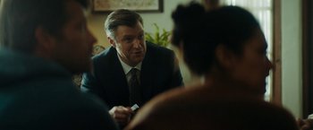 Movie still from “Encounter” (2021), directed by Michael Pearce – A man in a suit and tie talking to a woman; Close Up shot, Over the shoulder angle