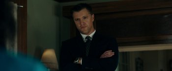 Movie still from “Encounter” (2021), directed by Michael Pearce – A person wearing a suit and tie; Close Up shot, Low angle