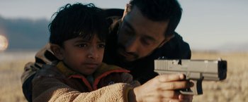 Movie still from “Encounter” (2021), directed by Michael Pearce – A man and a child looking at a camera; Close Up shot, Over the shoulder angle