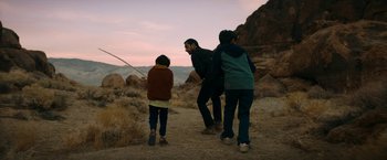 Movie still from “Encounter” (2021), directed by Michael Pearce – A man and two children are standing in the desert; Wide shot, Over the shoulder angle