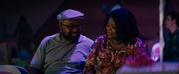 Movie still from “Encounter” (2021), directed by Michael Pearce – A man and a woman sitting next to each other; Medium shot, Over the shoulder angle