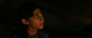 Movie still from “Encounter” (2021), directed by Michael Pearce – A young boy looking up into the dark; Close Up shot, High angle