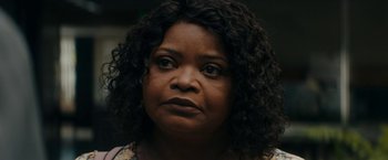 Movie still from “Encounter” (2021), directed by Michael Pearce – An older woman with black curly hair looking at the camera; Close Up shot, Over the shoulder angle