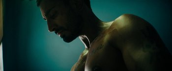 Movie still from “Encounter” (2021), directed by Michael Pearce – A person with tattoos on their chest; Close Up shot, Low angle