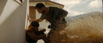Movie still from “Encounter” (2021), directed by Michael Pearce – A man and a boy are standing in the grass; Medium shot, Over the shoulder angle