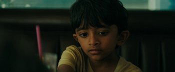Movie still from “Encounter” (2021), directed by Michael Pearce – A young boy is sitting in a chair; Close Up shot, High angle