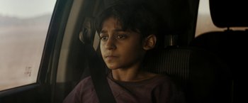 Movie still from “Encounter” (2021), directed by Michael Pearce – A boy sitting in the back seat of a car; Close Up shot, High angle