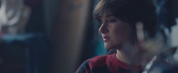 Movie still from “Endings, Beginnings” (2019), directed by Drake Doremus – A person wearing a red and black sweater; Close Up shot, High angle