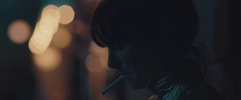 Movie still from “Endings, Beginnings” (2019), directed by Drake Doremus – A woman is smoking a cigarette in the dark; Extreme Close Up shot, Over the shoulder angle