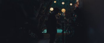 Movie still from “Endings, Beginnings” (2019), directed by Drake Doremus – A man standing in the dark near some lights; Wide shot, Over the shoulder angle