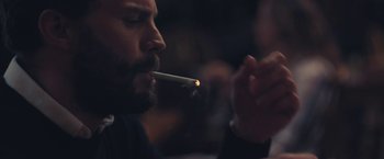 Movie still from “Endings, Beginnings” (2019), directed by Drake Doremus – A man smoking a cigarette while holding a lit cigarette; Close Up shot, Over the shoulder angle
