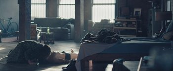 Movie still from “Endings, Beginnings” (2019), directed by Drake Doremus – A person laying on the floor in a living room; Wide shot, High angle
