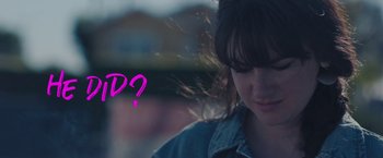 Movie still from “Endings, Beginnings” (2019), directed by Drake Doremus – A woman with a pink sign in front of her face; Close Up shot, Over the shoulder angle